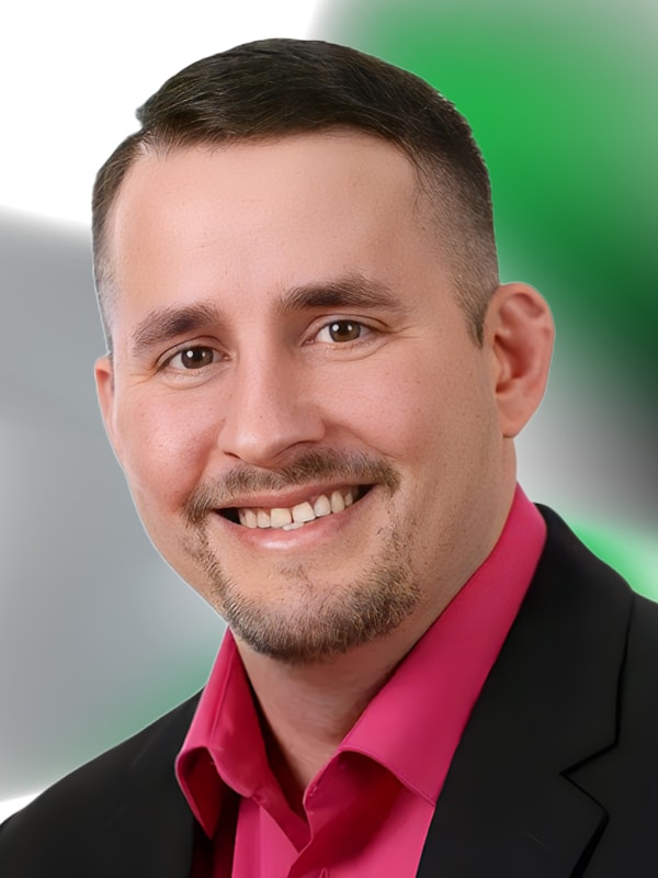 Jason Black, Senior Loan Originator, smiling portrait with a pink shirt and black blazer, professional background.