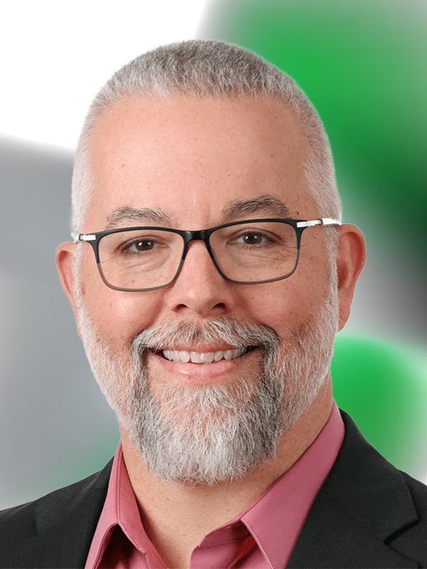 Portrait of a mortgage professional with a beard and glasses, smiling against a blurred background, representing expertise in home loans and personalized financial guidance.